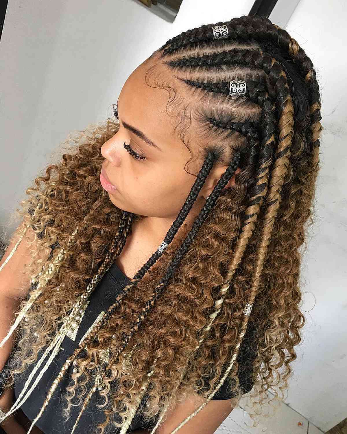 Intricate braided hairstyle with curly brown and blonde hair extensions